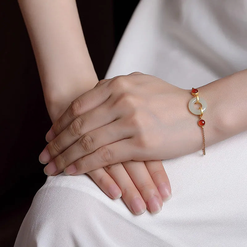 Gold-coloured women's bracelet with a silver base and an inlaid Hetian jade peace buckle charm.