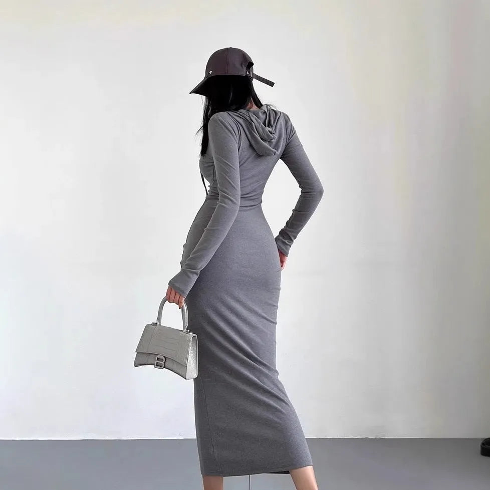 A woman modelling a grey hooded long-sleeve sheath dress with a high waist.