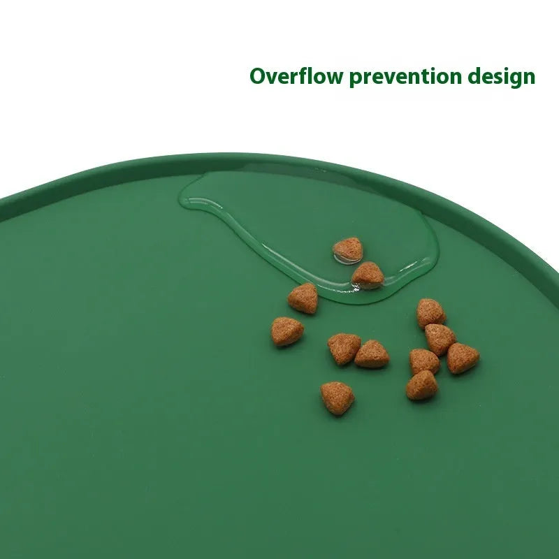 Beige silicone cat feeding mat with raised edge containing a food bowl and scattered kibble on a kitchen floor.