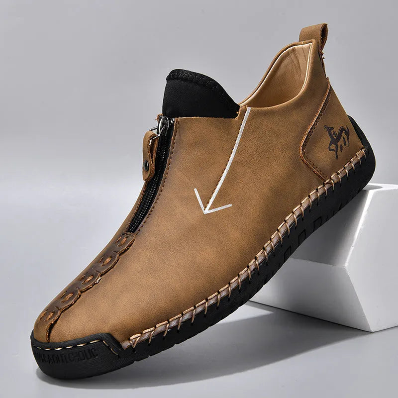 Men's black leather ankle boots with a front zip and round toe on a rubber sole
