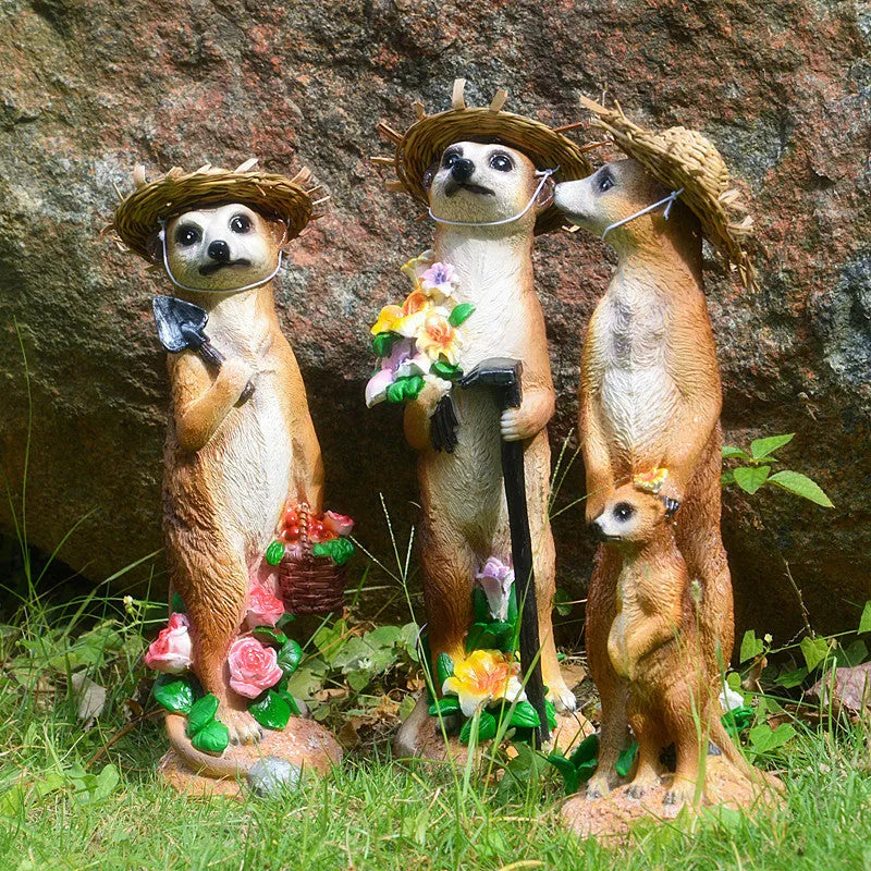Three straw hat mongoose garden ornaments including mother and child grouping plus figures with rake and shovel