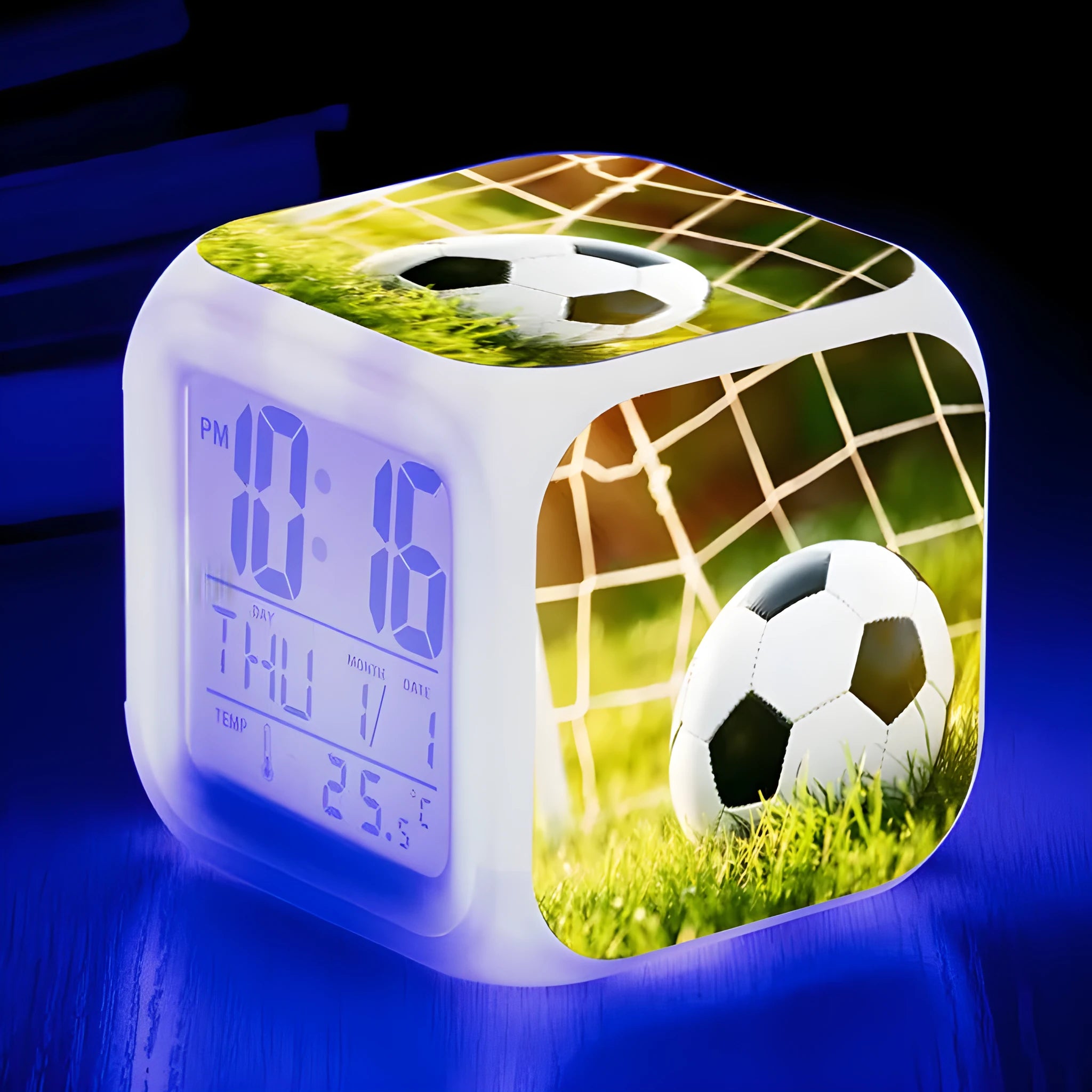 Square cartoon football pattern children's alarm clock with mute alarm on a bedside table.