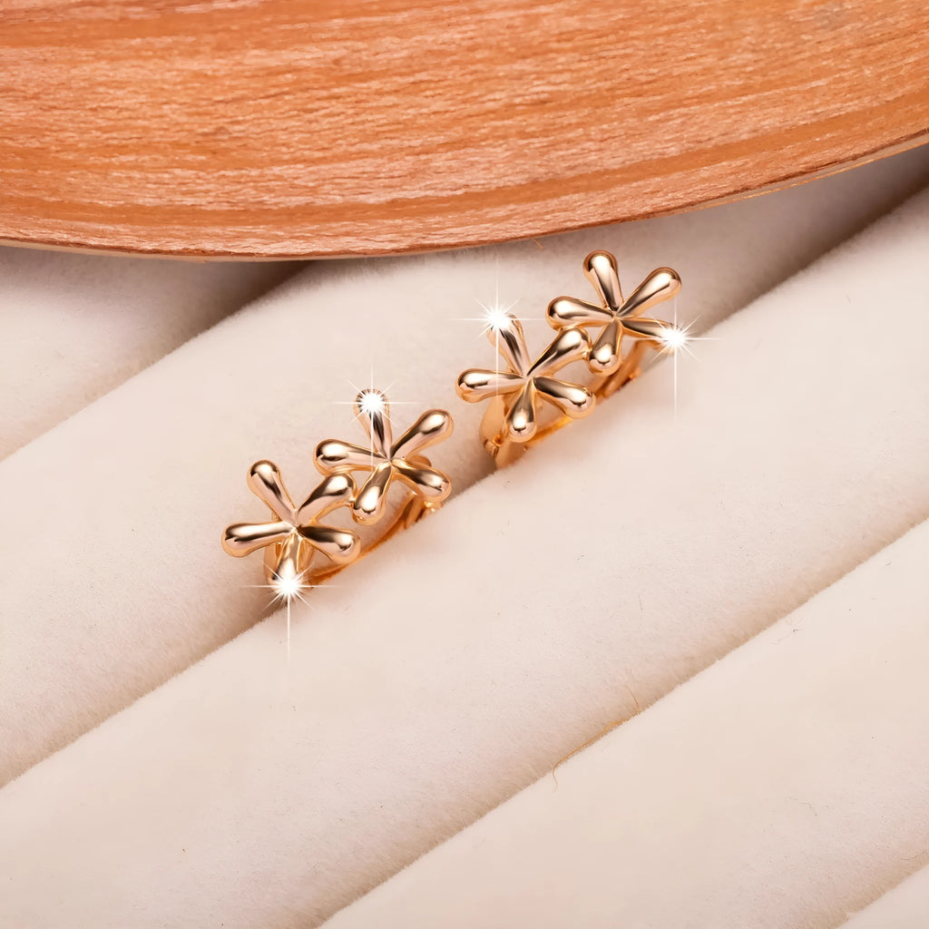 Rose gold circular waterdrop flower earrings with sterling silver posts on a white background.