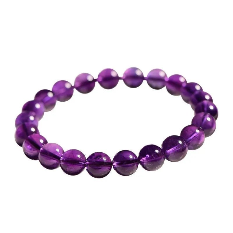Loose polished amethyst beads on an elastic cord, forming a natural Uruguay crystal bracelet in violet shades.
