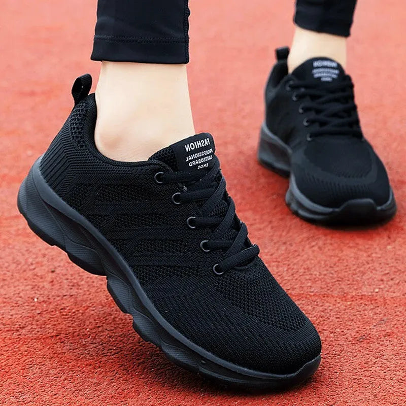 Women's white mesh leisure shoes with lace-up closure and low heel on neutral background