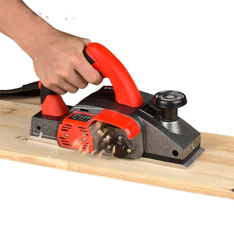 Red aluminium-shell electric wood planer with 82mm planing width and 1400W motor for carpentry tasks.