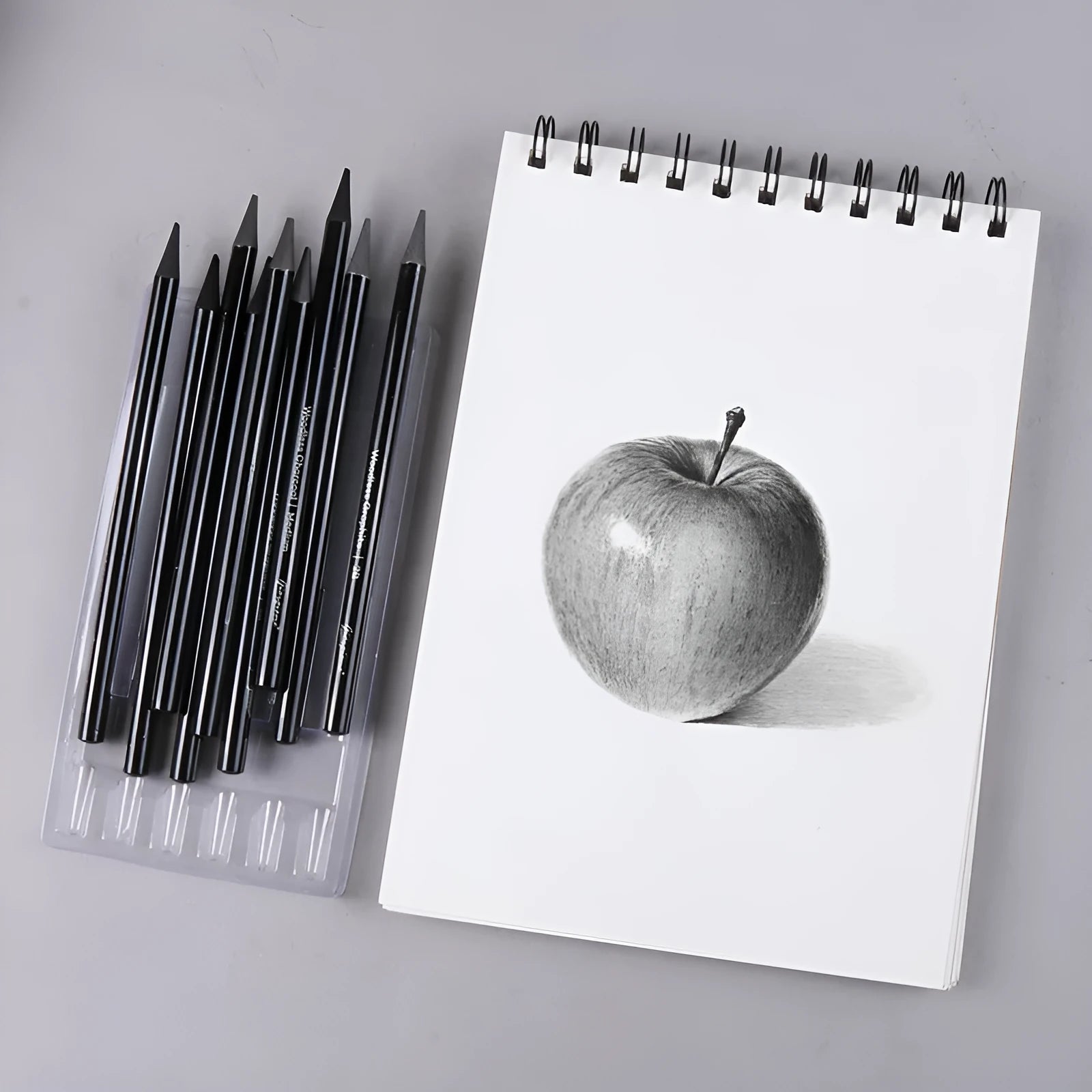 Set of nine drawing pencils with wooden shells, comprising six graphite and three carbonised pencils, on a suction card.