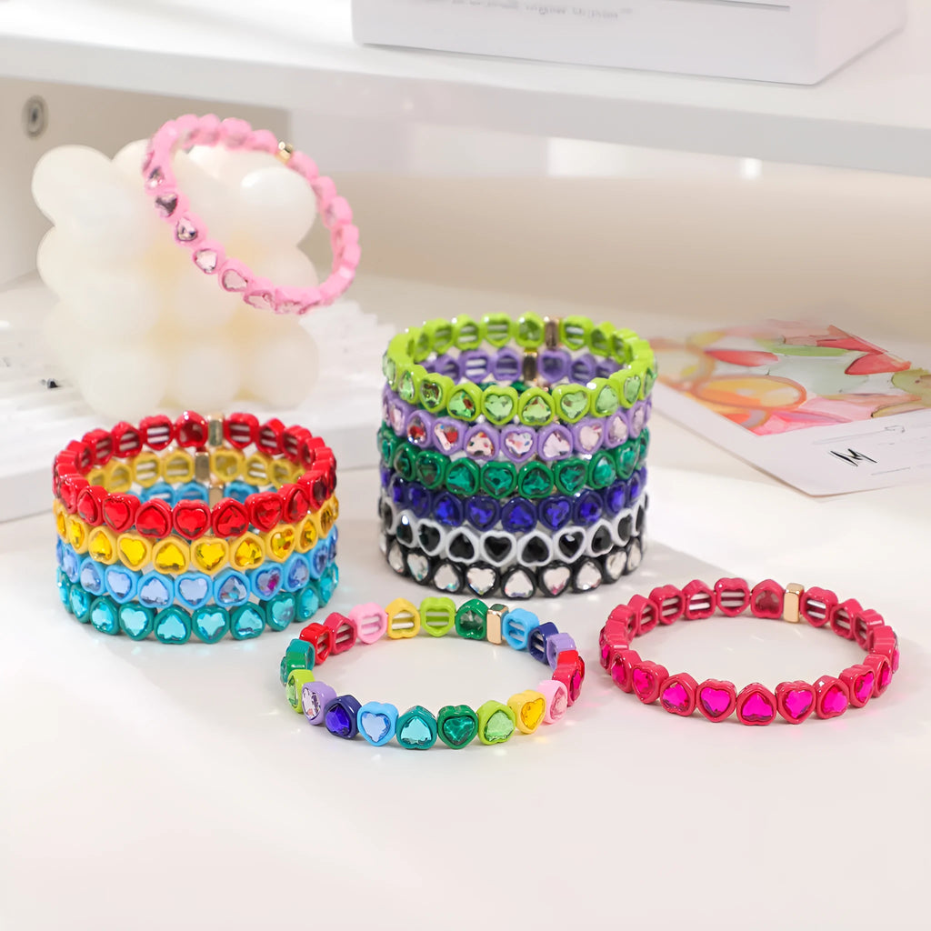 Colourful elastic bracelet with a shiny heart-shaped alloy charm on a stretch band.