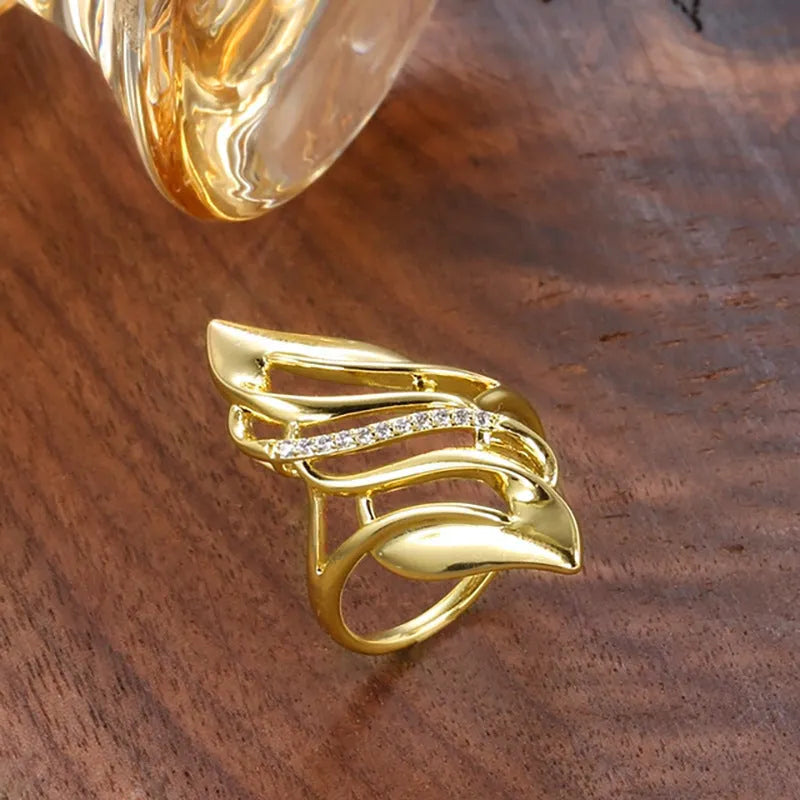 Women's exaggerated curve statement ring in gold colour with bold design on finger