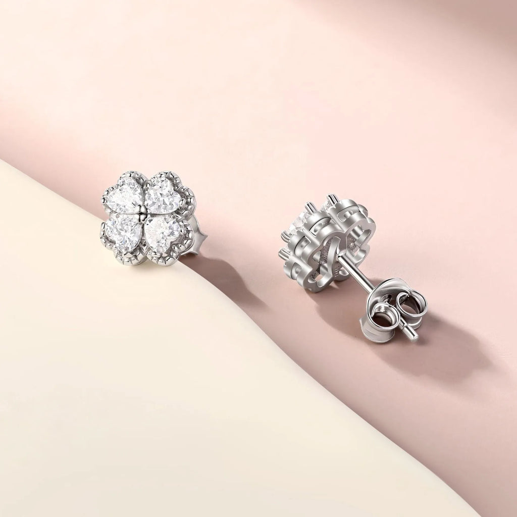 A pair of 925 silver earrings with a heart and four-leaf clover design, set with zircon stones in a white gold colour finish.