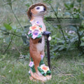 Three straw hat mongoose garden ornaments including mother and child grouping plus figures with rake and shovel