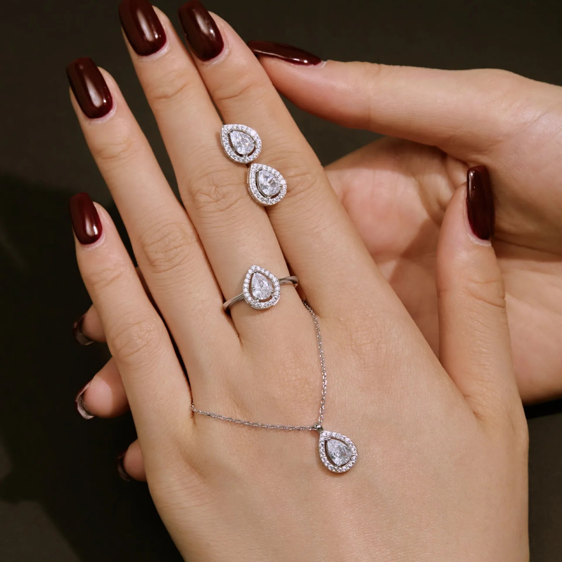 S925 sterling silver ring with drop-shaped diamond zircon stone in light luxury style on a plain background