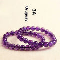 Loose polished amethyst beads on an elastic cord, forming a natural Uruguay crystal bracelet in violet shades.