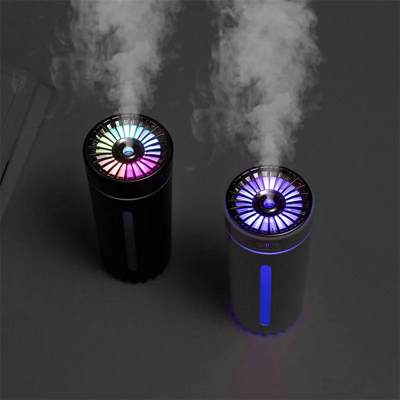 Black wireless USB car humidifier with colourful LED lights on a desktop next to a cup holder.