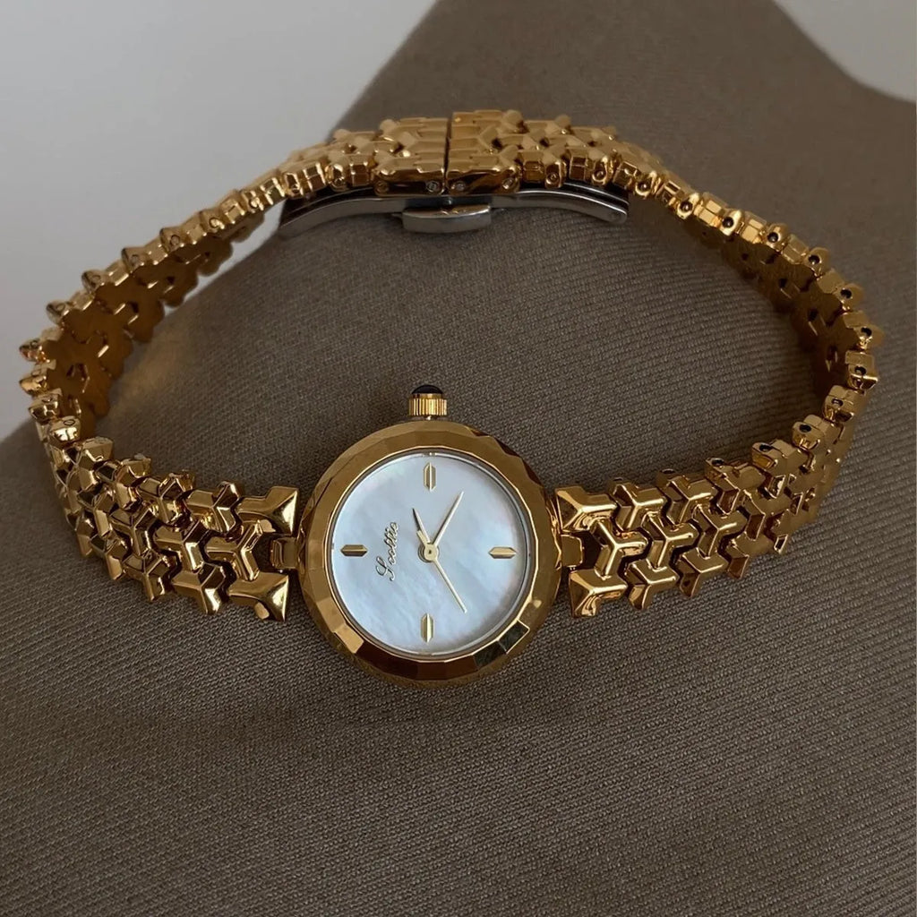 Women's thin 8mm alloy watch with white shell dial and gold strap on wrist