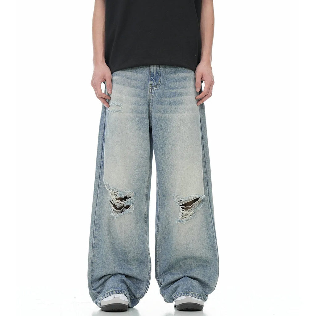 Blue men's straight-leg jeans with ripped detailing and a zip fly on a plain background.