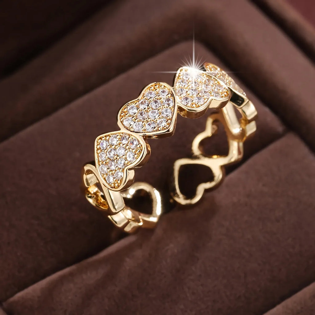 Geometric adjustable opening ring with a love heart detail in a choice of gold or silver tone finish.
