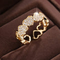 Geometric adjustable opening ring with a love heart detail in a choice of gold or silver tone finish.