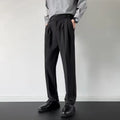 Men's straight leg loose fit suit trousers in apricot colour hanging on a hanger.