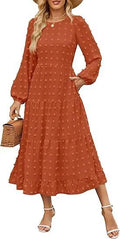 A woman wearing a beige high-waist long sleeve dress with ruffle detailing on the sleeves.