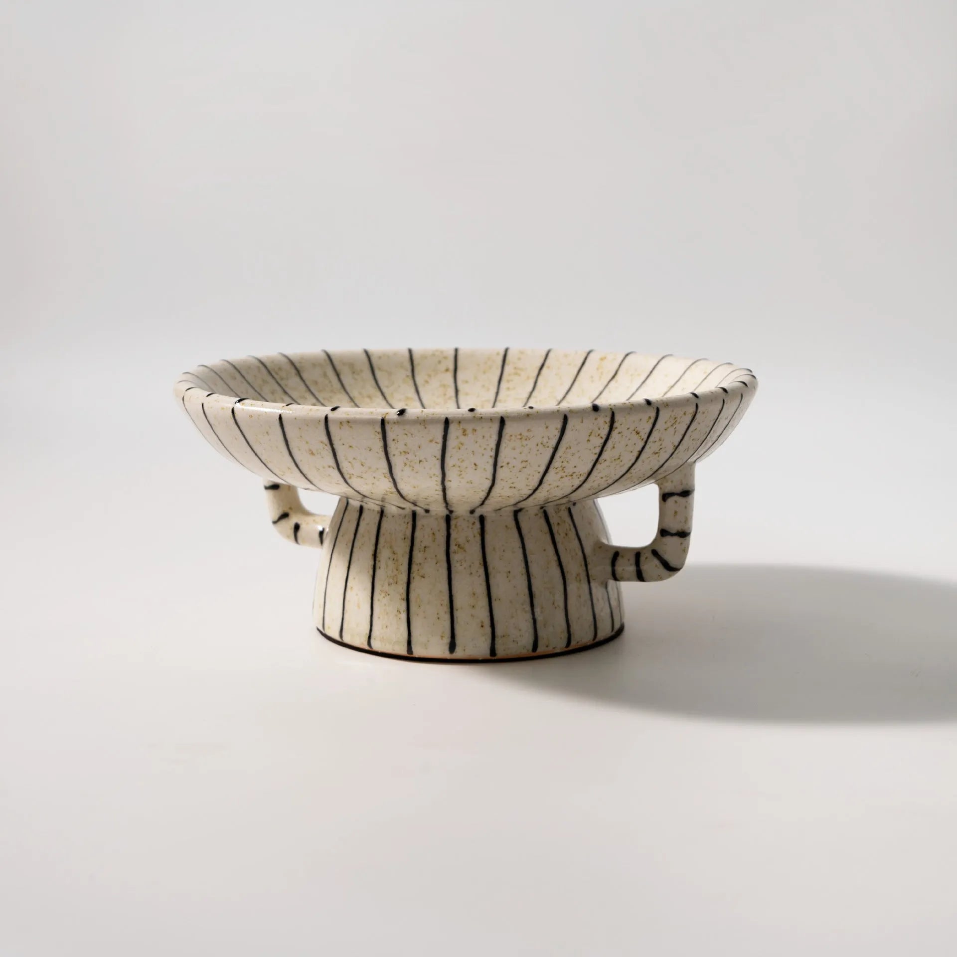 Black and white striped synthetic resin fruit plate on a table