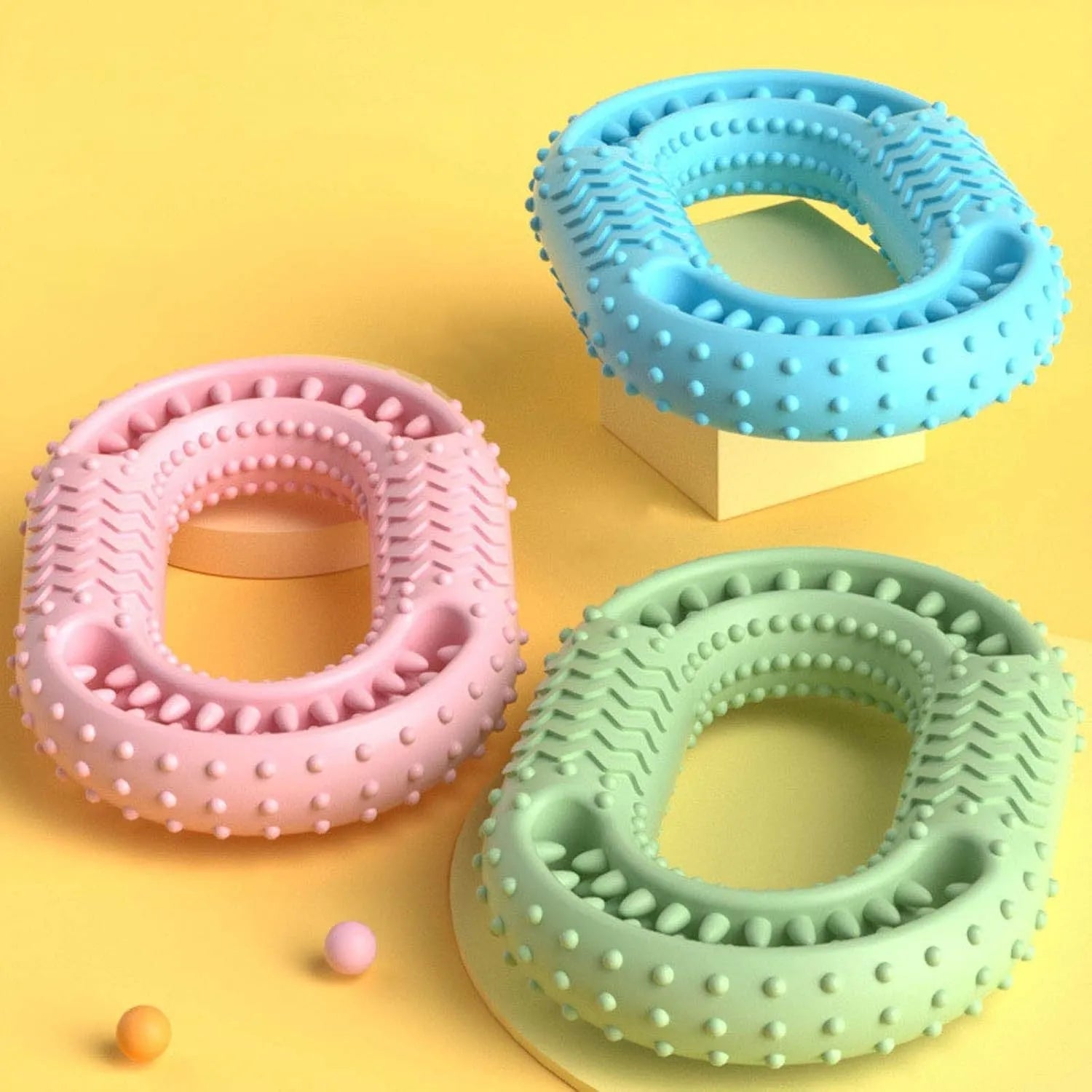 Blue, green, and pink O-ring shaped heavy chew resistant dog toy for aggressive chewers.