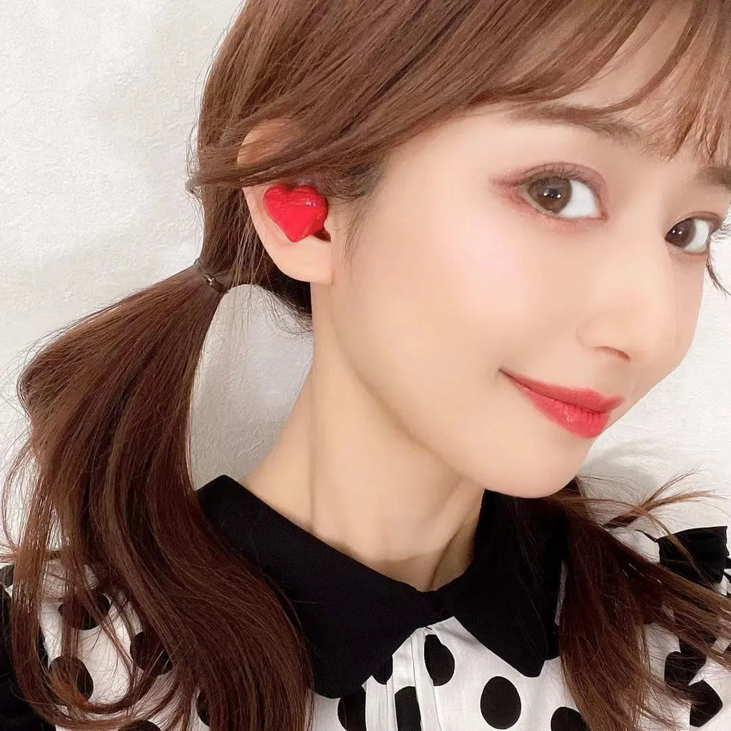 Heart-shaped wireless Bluetooth earphones in Chinese red and girl pink colours with charging cable