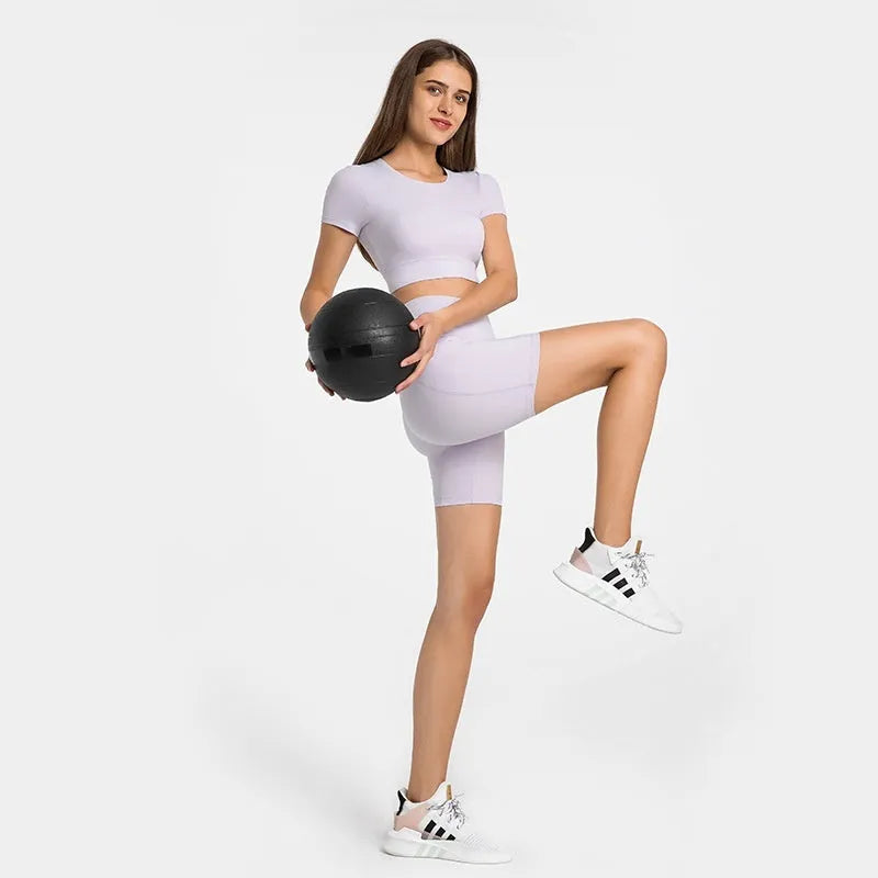 Women's solid colour mid-length sports shorts with a tight fit and waistband.