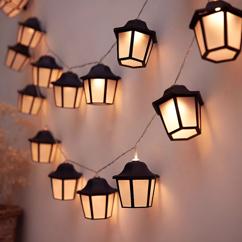 Solar LED lighting chain with warm white retro lamps on a garden fence at dusk