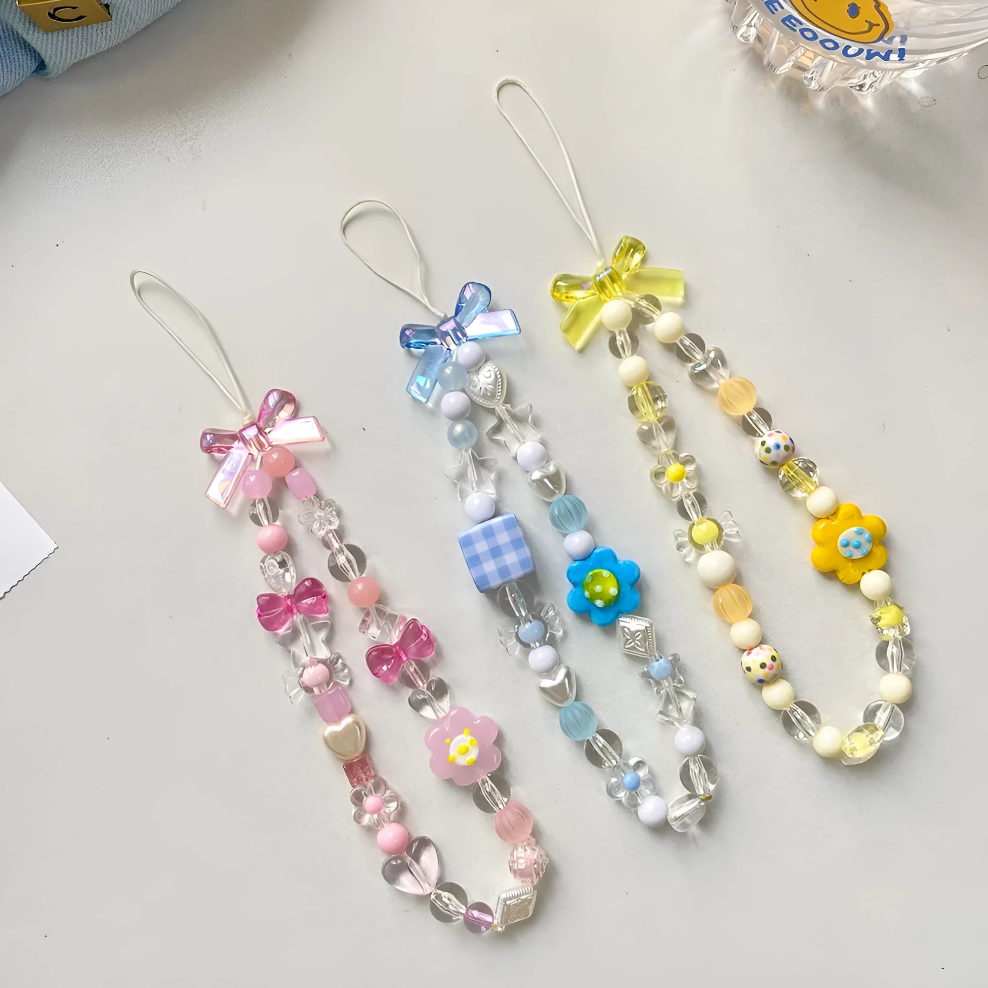 A blue beaded flower mobile phone lanyard with a hand rope design, measuring 1 metre long.