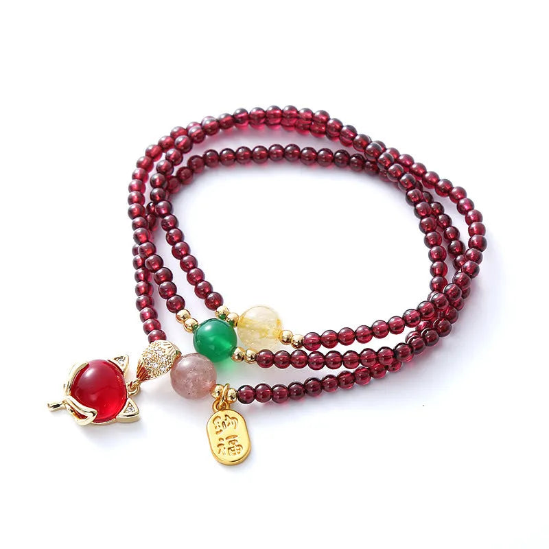 Purplish red adjustable rope bracelet with a detailed natural garnet fox charm.