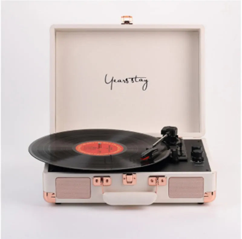 Portable Bluetooth vinyl turntable in a leather carrying case shown in multiple colour options