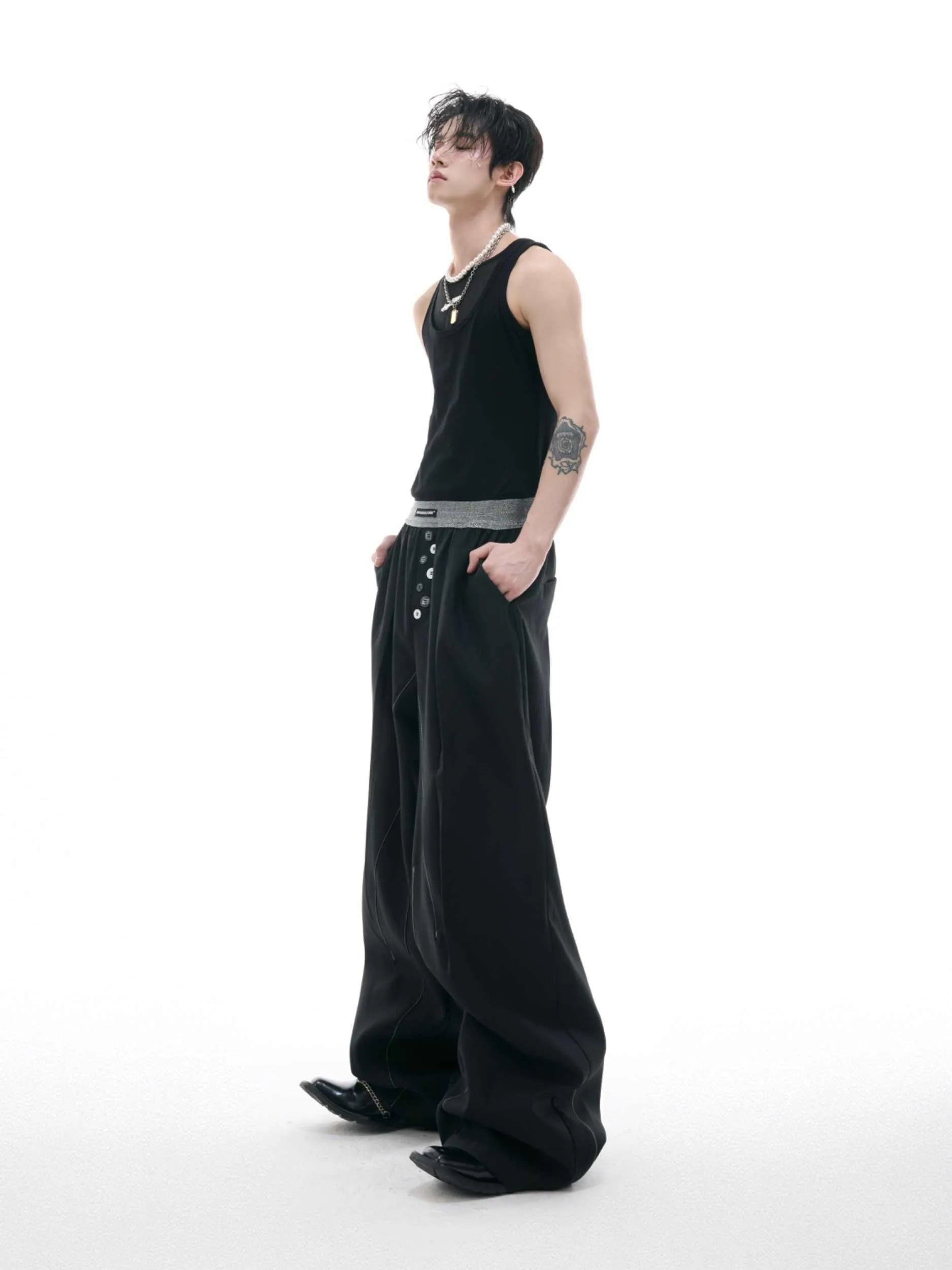 Drooping straight suit pants in black or grey with a high waist and button-open line detail.