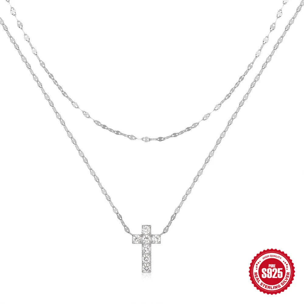 Close-up of a sterling silver double layer twin diamond cross pendant necklace on an adjustable chain.