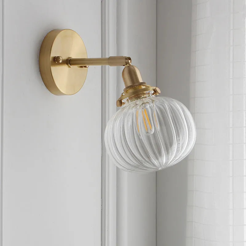 Creative pumpkin-shaped wall lamp with a textured water ripple glass shade mounted on a white wall