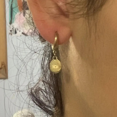 A pair of stainless steel geometric earrings with ellipse design details on a white background.