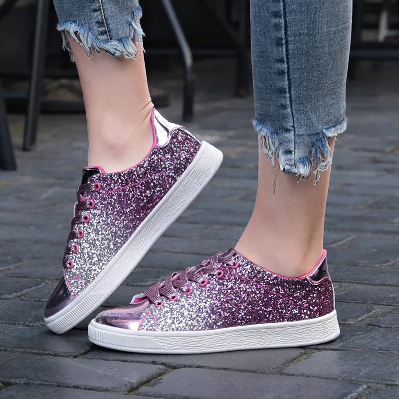 Women's black, gold, and pink sequinned low-top lace-up shoes on a white background.