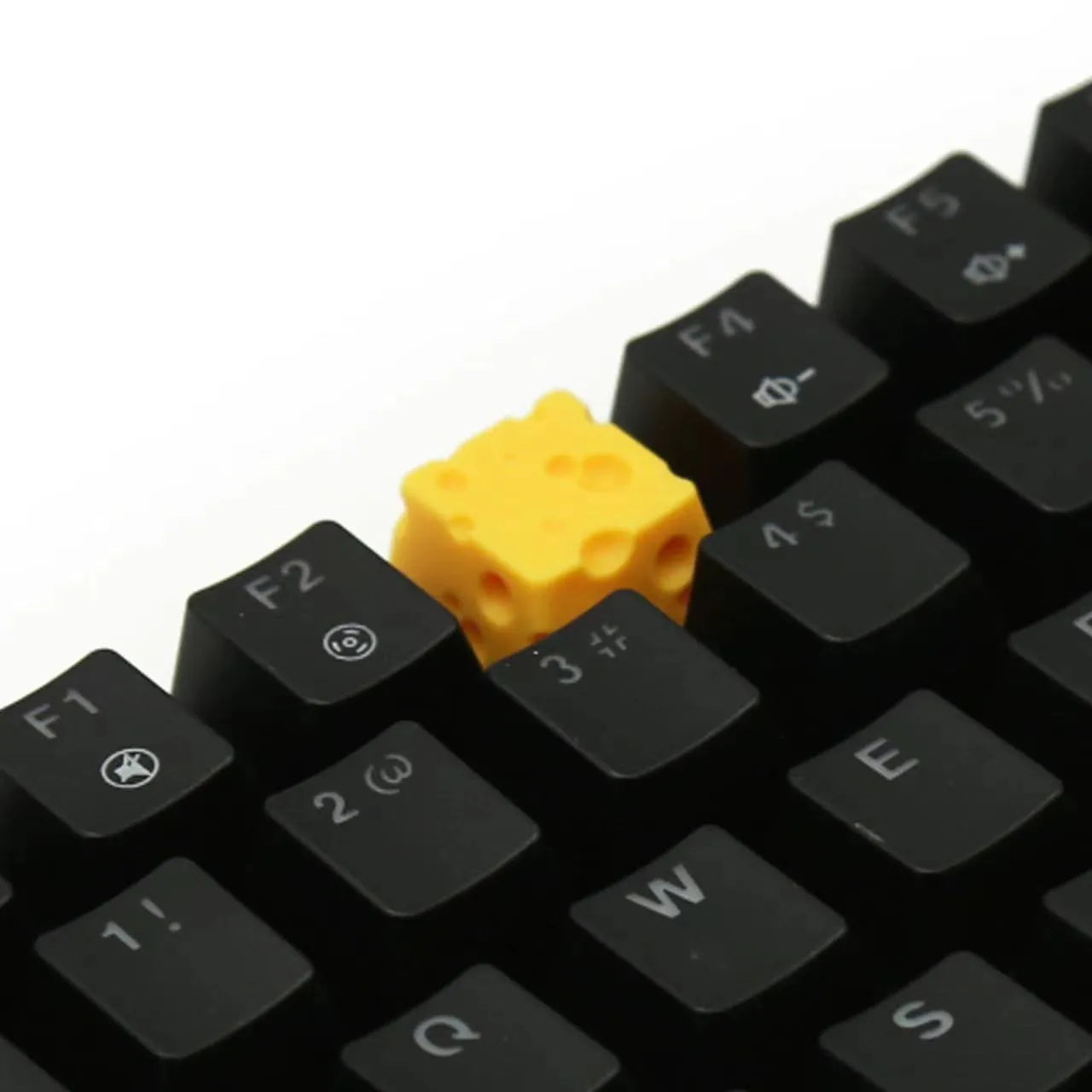 Yellow resin cheese-shaped key cap for mechanical keyboards, shown from a top-down angle.