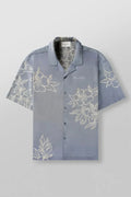 Man's loose-fitting printed short sleeve top in a light colour, showing cardigan style and floral pattern detail.