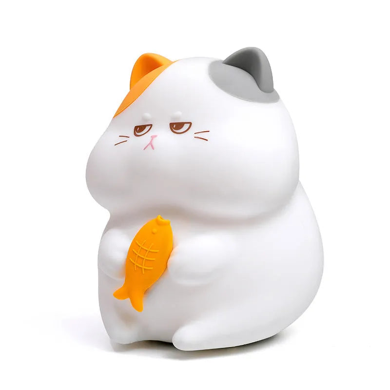 Yellow Greedy Cat cartoon desktop night light with USB cable on a wooden desk.