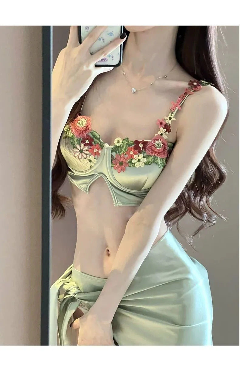 Green women's three-piece bikini set showing triangle top, briefs, and matching skirt on a white background.