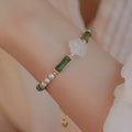 Close-up of a handcrafted Chinese antique style bracelet with bamboo joint design, featuring Hetian jade and 4mm shell pearls with copper details.