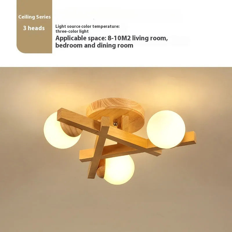 Modern black and copper three-headed pendant ceiling light with adjustable arms hanging over a wooden table