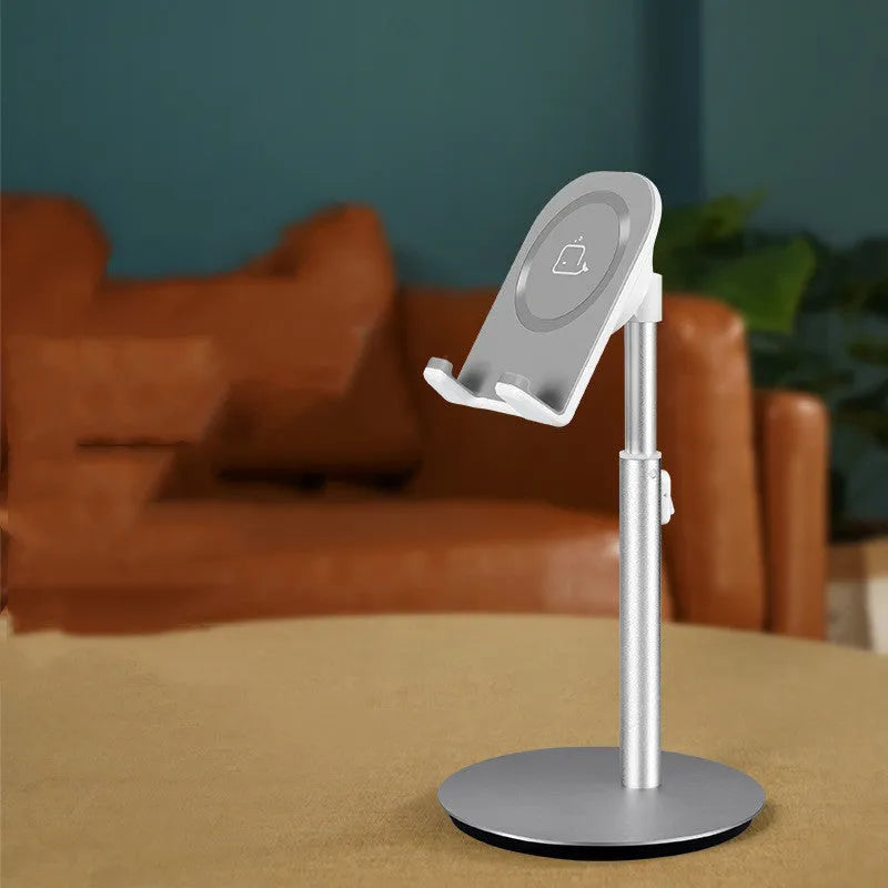 Silver metal computer phone holder stand for smartphones and tablets on a desktop.