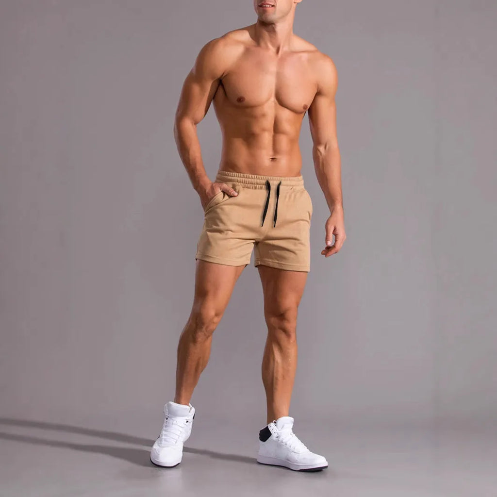 Three pairs of men's solid colour shorts with elastic drawstring waists in black, khaki and light brown