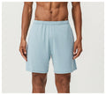 Man wearing brick red double-layer running shorts with a moisture-wicking fabric and inner compression liner.