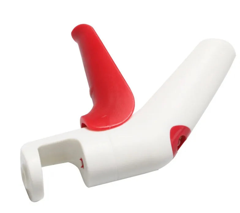 Stainless steel manual cherry pitter tool with protective end caps on a wooden surface.