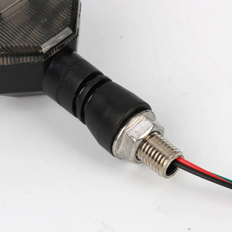 Arrow-shaped LED motorcycle turn signal light unit for 12V vehicles, shown in available colour options.