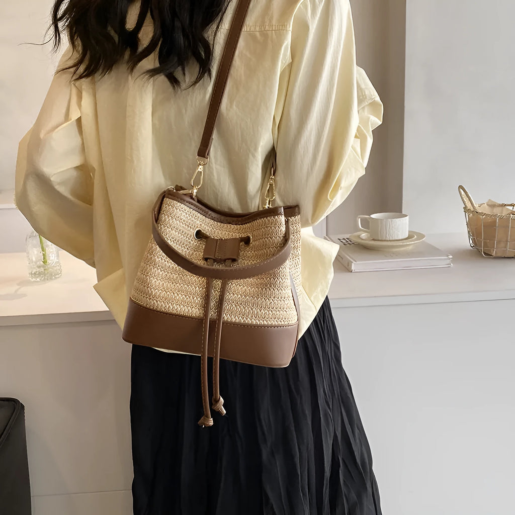 Brown woven straw women's crossbody bucket bag with horizontal square shape and adjustable strap
