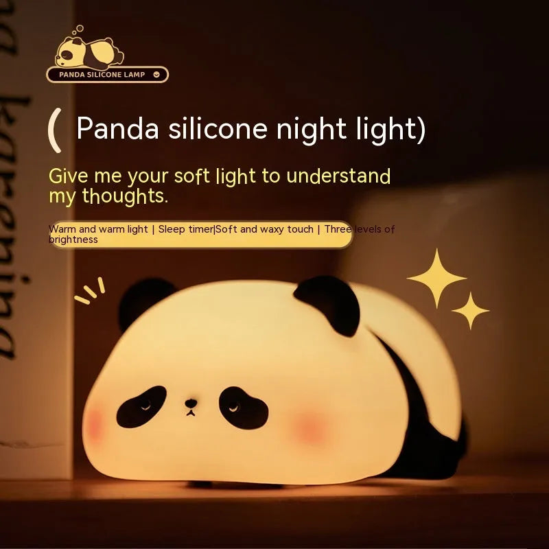 Cartoon panda head shaped silicone night light for children on a bedside table.